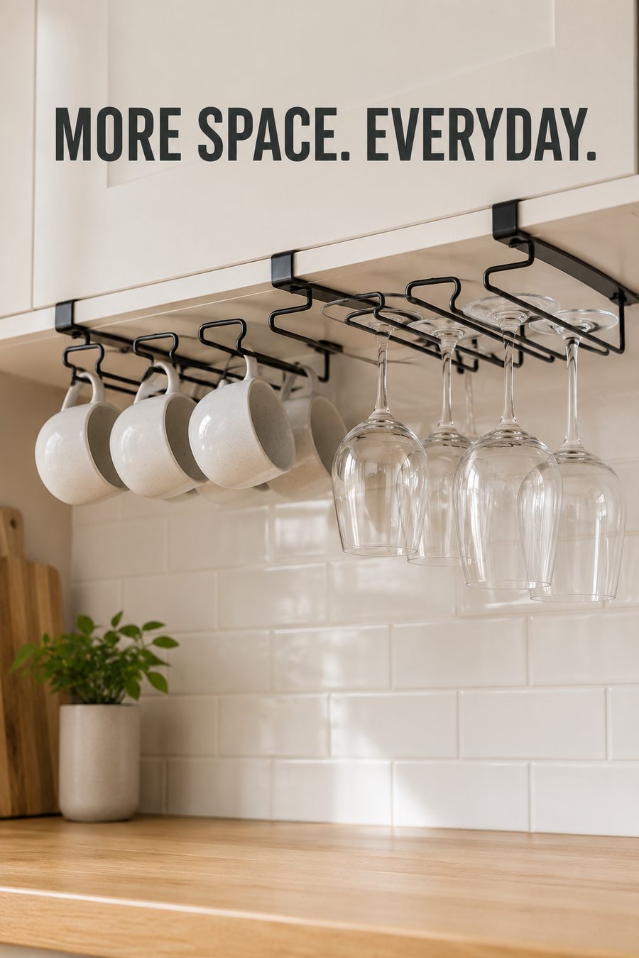 Black under-cabinet rack holding mugs and wine glasses neatly beneath white kitchen cabinets in a bright modern kitchen.