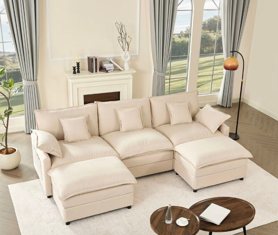 Cream linen U-shaped modular sectional sofa with two movable ottomans in a bright living room